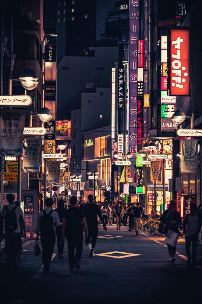 People Walking on the Street Between Buildings